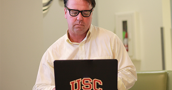 David Rochman researches on his laptop