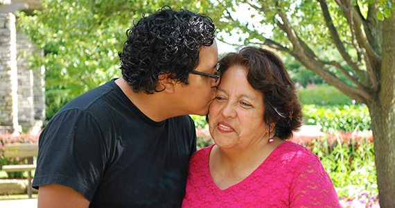 Latino son kissing his mother
