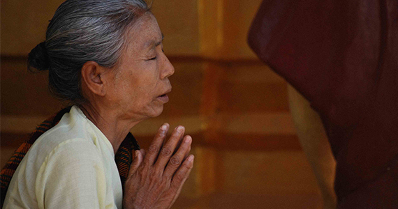 Older Asian woman praying