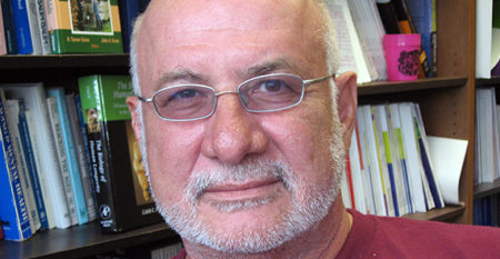 Dr. Markides sitting in his office near book shelf