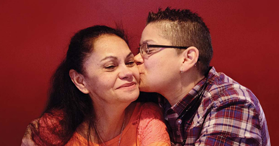 Latino woman being kissed on the cheek by her caregiver