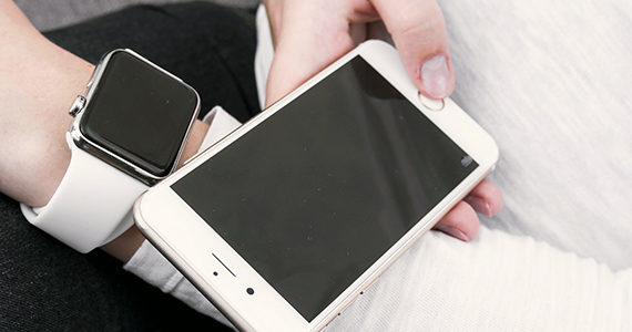 Person using iPhone and wearing Apple watch