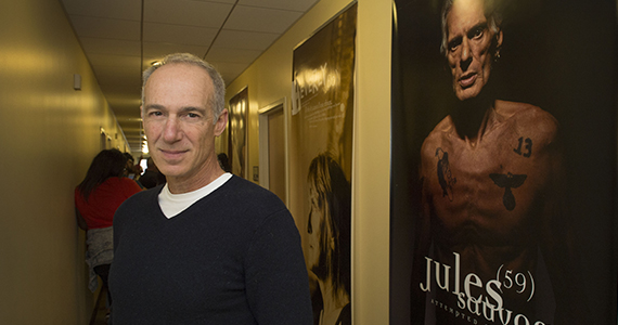 Ron Levine stands next to one of the photos at USC.