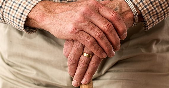 Photo zoomed in on old man's hand holding his cane.