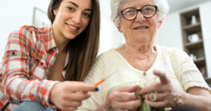Granddaughter learning how to knit from her grandma