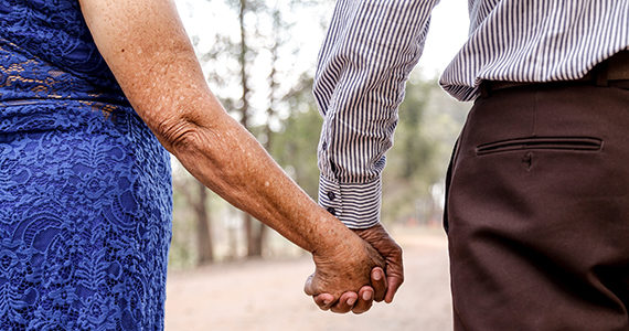 Older Latino couple walking in the park