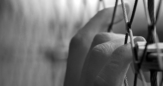 hands resting on caged fence