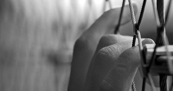 hands resting on caged fence
