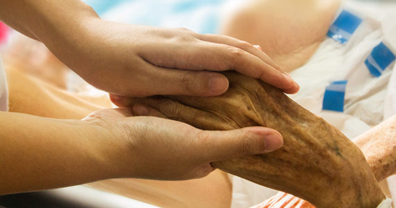 someone holding hands of a hospice patient