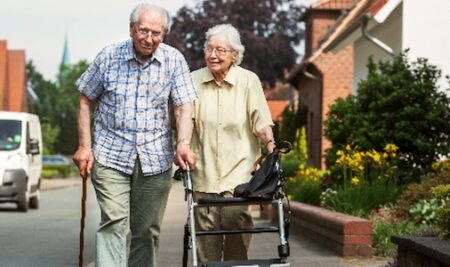 older couple walking on neighborhood sidewalk