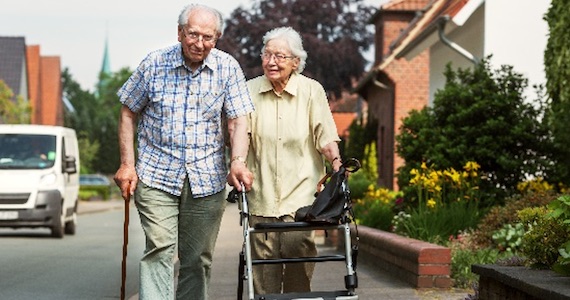 older couple walking on neighborhood sidewalk