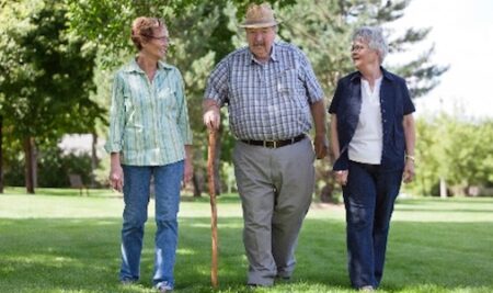 a man and two women walking in the park