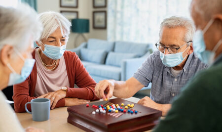 Senior friends playing chinese checkers at nursing home