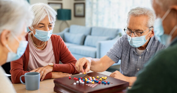 Senior friends playing chinese checkers at nursing home