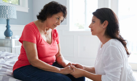 Adult Daughter Comforting Mother Suffering With Dementia