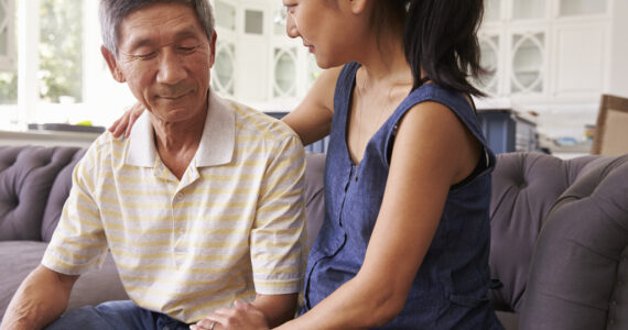 Adult Daughter Talking To Depressed Father At Home